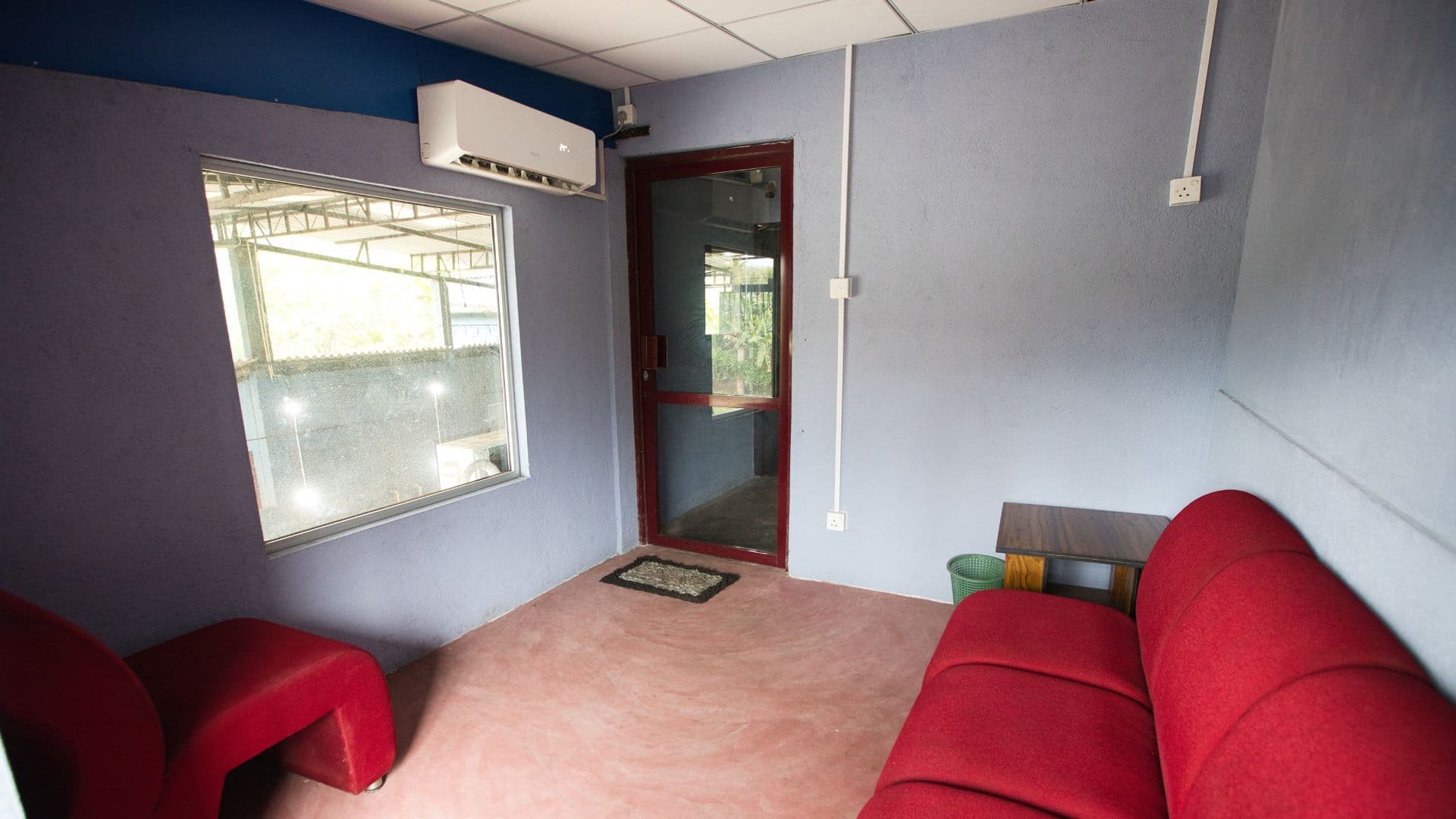 Air-conditioned customer waiting lounge with comfortable seating and viewing window at CarVibes