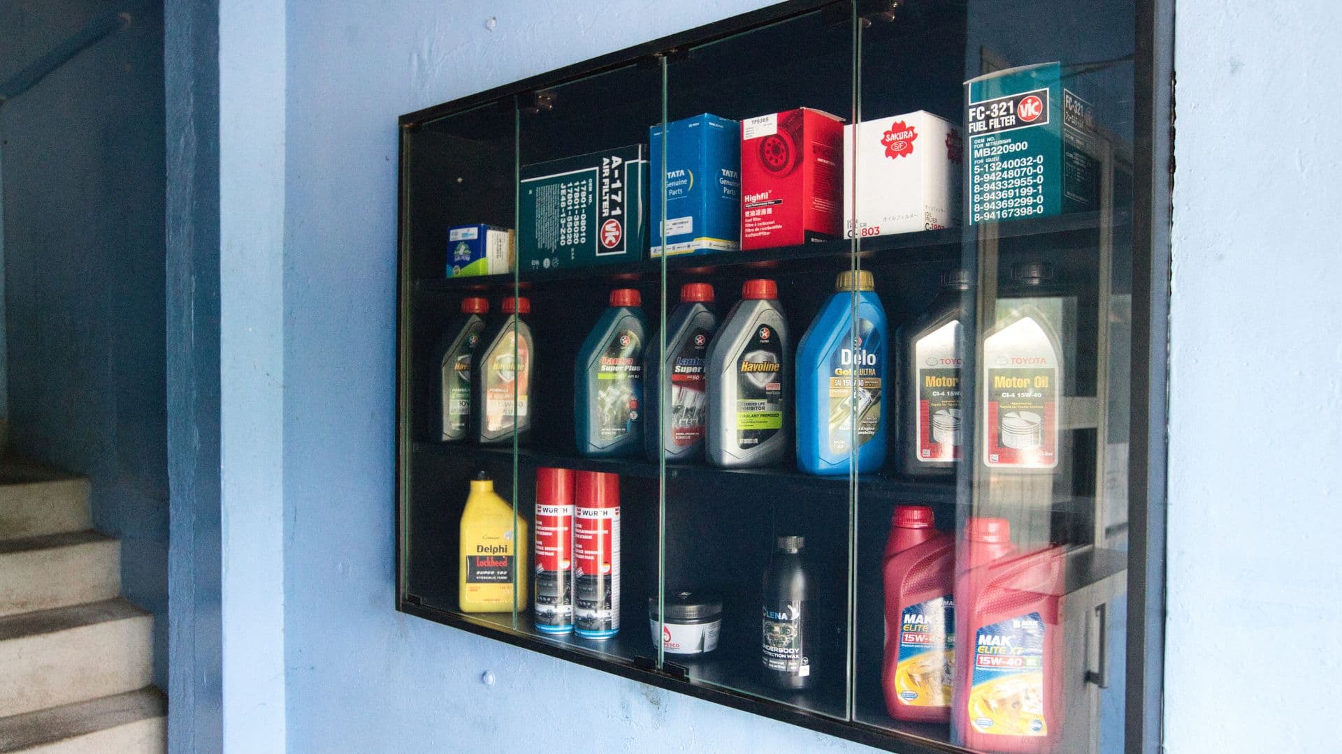 Cabinet displaying genuine motor oils, filters, and professional Würth car detailing chemicals
